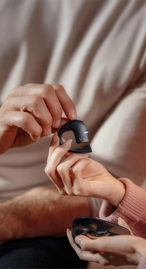 A person handing the Vasco Translator E1 to another person, demonstrating its use and highlighting the 10 translation engines it supports.