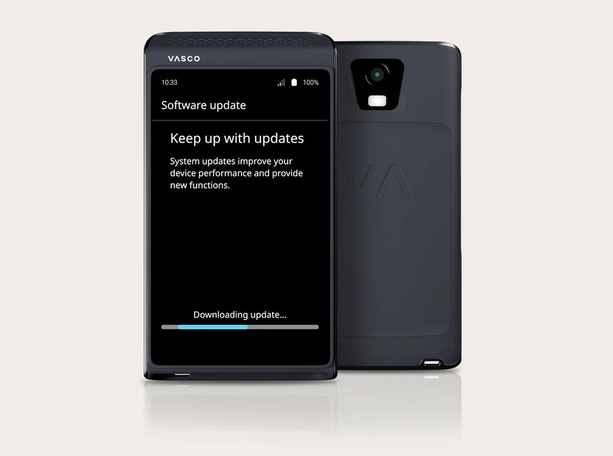A studio shot of the Vasco Translator Q1 showcasing the software update process. Two devices are shown: one from the front and one from the back. The front device displays a 